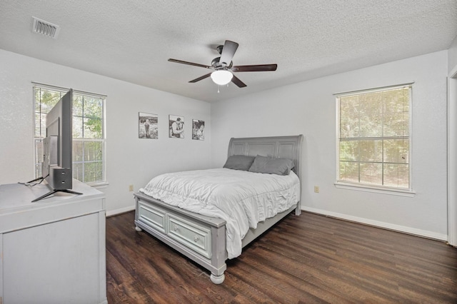 bedroom featuring a textured ceiling, ceiling fan, and dark hardwood / wood-style floors