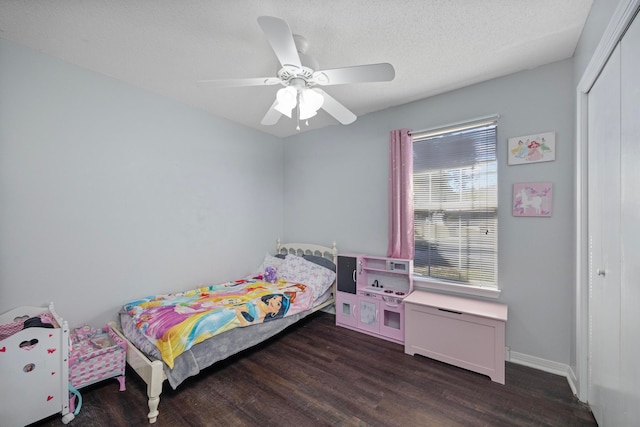 bedroom with ceiling fan, multiple windows, dark hardwood / wood-style floors, and a closet