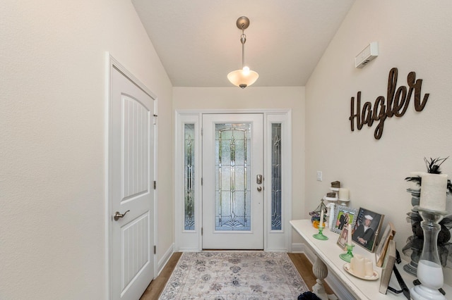entryway with baseboards and wood finished floors