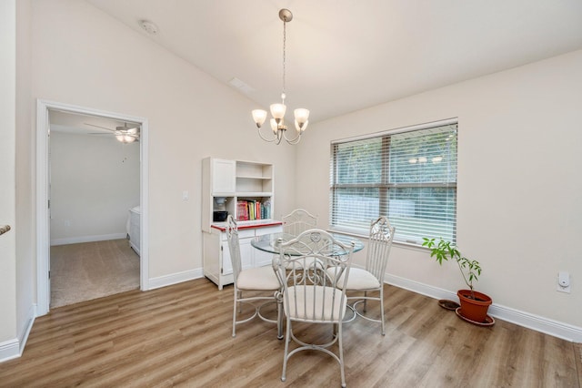 dining room featuring baseboards, vaulted ceiling, light wood finished floors, and ceiling fan with notable chandelier