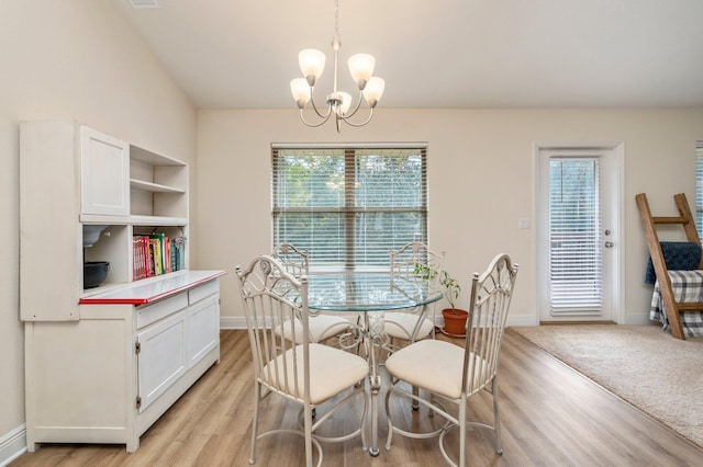 dining space with baseboards, a notable chandelier, and light wood finished floors