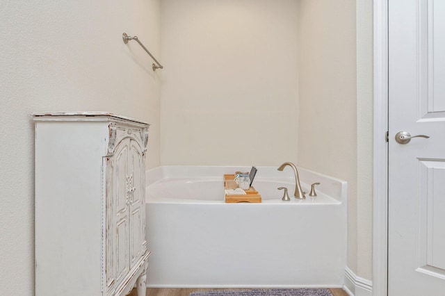 full bath with wood finished floors and a bath