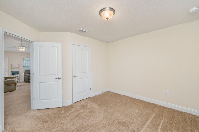unfurnished bedroom featuring carpet floors, baseboards, and visible vents