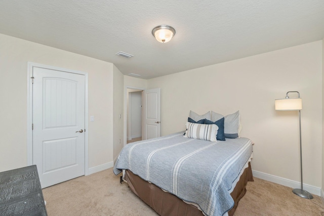 carpeted bedroom featuring baseboards and visible vents