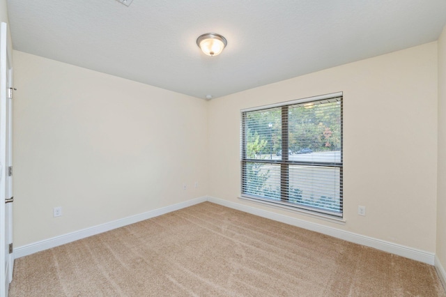 empty room with light colored carpet and baseboards