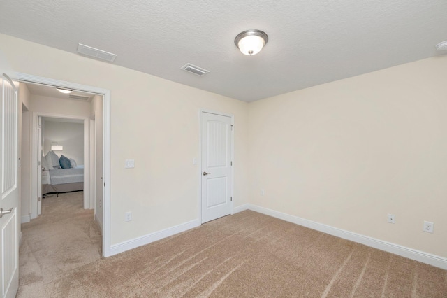 unfurnished bedroom with baseboards, visible vents, and light colored carpet