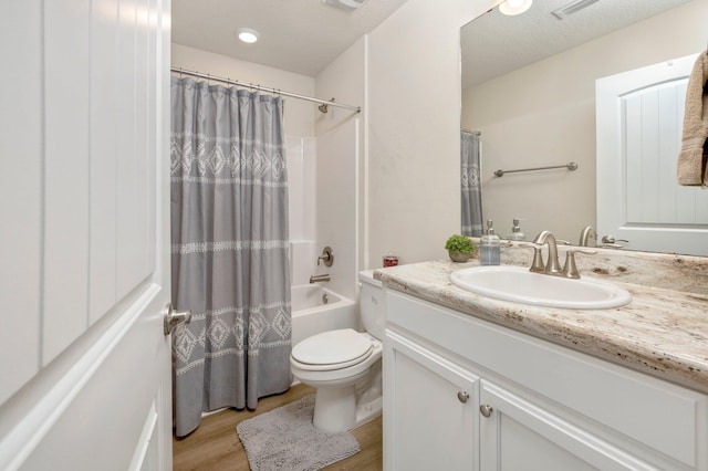 bathroom featuring vanity, toilet, wood finished floors, and shower / bath combination with curtain