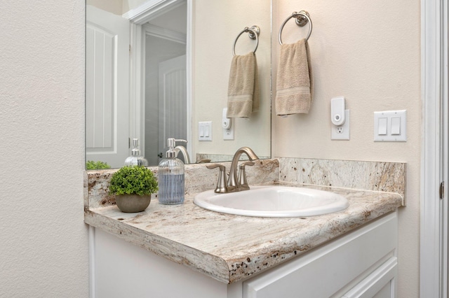bathroom with vanity and a textured wall