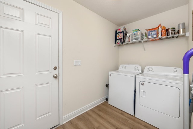 clothes washing area with light wood-style floors, baseboards, laundry area, and washing machine and dryer