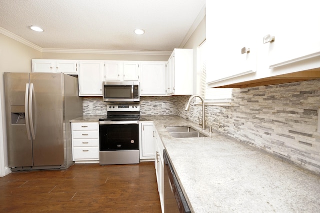 kitchen featuring dark wood-type flooring, sink, appliances with stainless steel finishes, tasteful backsplash, and white cabinetry