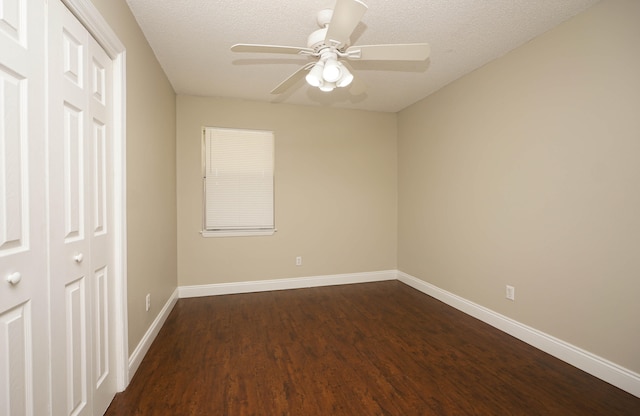 unfurnished room with ceiling fan, dark hardwood / wood-style flooring, and a textured ceiling