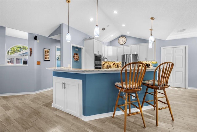 kitchen with white cabinets, stainless steel refrigerator with ice dispenser, decorative light fixtures, and vaulted ceiling