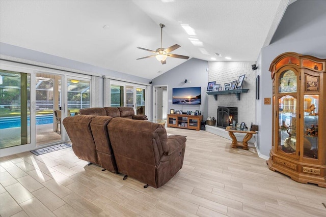 living room with a fireplace, ceiling fan, light hardwood / wood-style flooring, and lofted ceiling