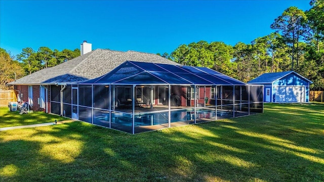 back of house featuring an outbuilding, glass enclosure, and a yard