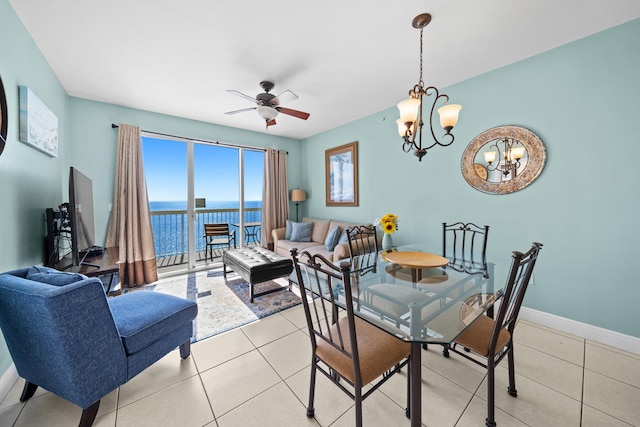 tiled dining room featuring ceiling fan with notable chandelier