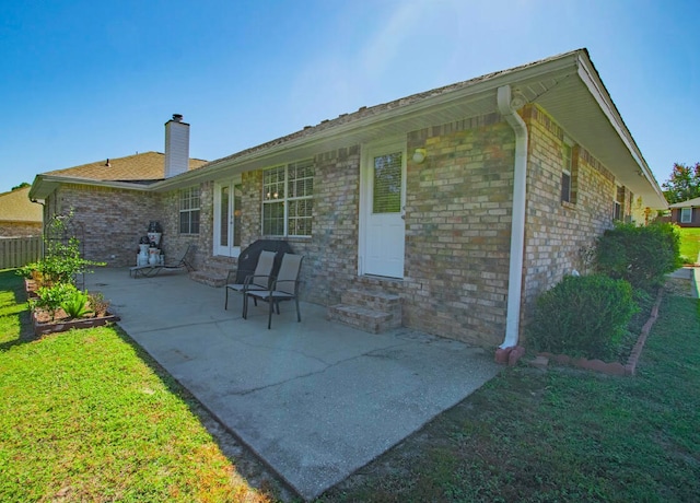 rear view of house with a yard and a patio area