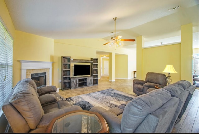 living room with light hardwood / wood-style flooring, lofted ceiling, a fireplace, and ceiling fan