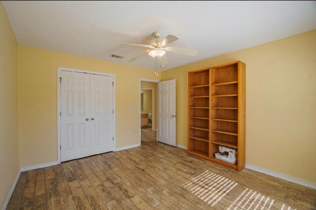 unfurnished bedroom with light hardwood / wood-style floors, a closet, and ceiling fan