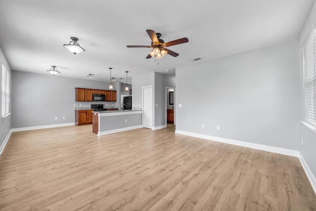 unfurnished living room featuring light hardwood / wood-style floors and ceiling fan