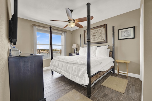 bedroom with dark hardwood / wood-style flooring and ceiling fan