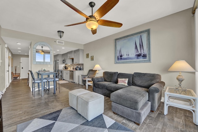 living room featuring sink, hardwood / wood-style floors, and ceiling fan