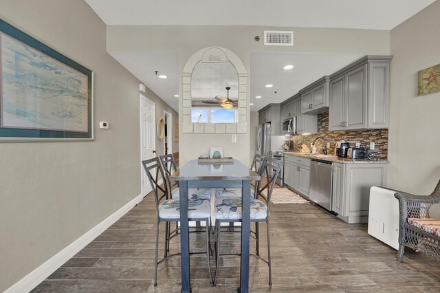 dining area with sink, dark wood-type flooring, and ceiling fan