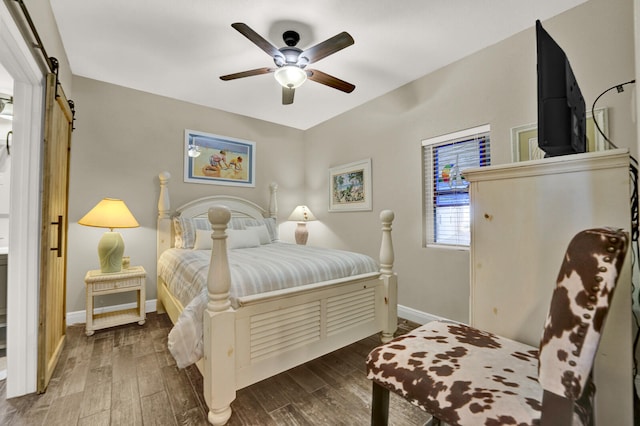 bedroom featuring a barn door, dark hardwood / wood-style floors, and ceiling fan