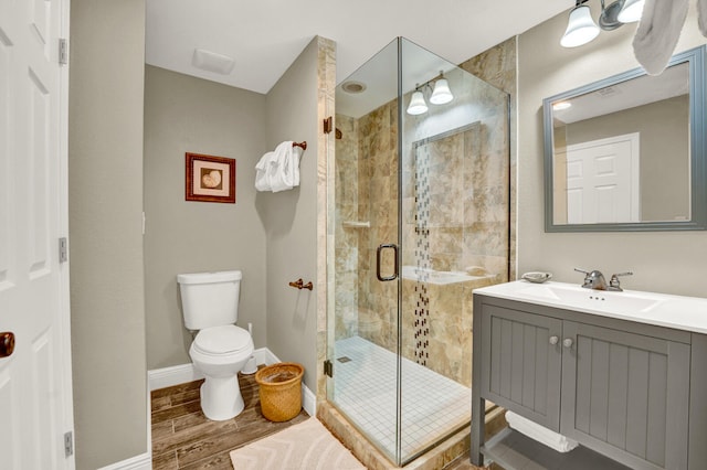 bathroom featuring a shower with door, toilet, hardwood / wood-style flooring, and vanity