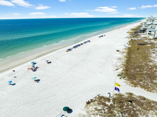 drone / aerial view featuring a water view and a view of the beach