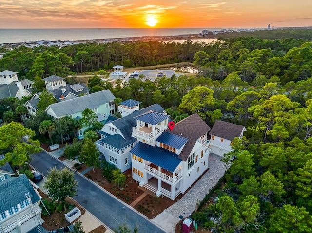 birds eye view of property featuring a water view and a wooded view