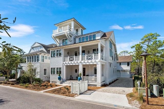 view of front of property with decorative driveway, a balcony, and a porch