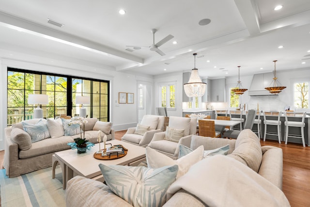 living room featuring visible vents, baseboards, beamed ceiling, recessed lighting, and light wood-style floors