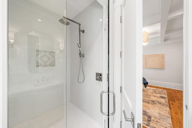 full bathroom with wood finished floors, coffered ceiling, a sink, a shower stall, and beamed ceiling