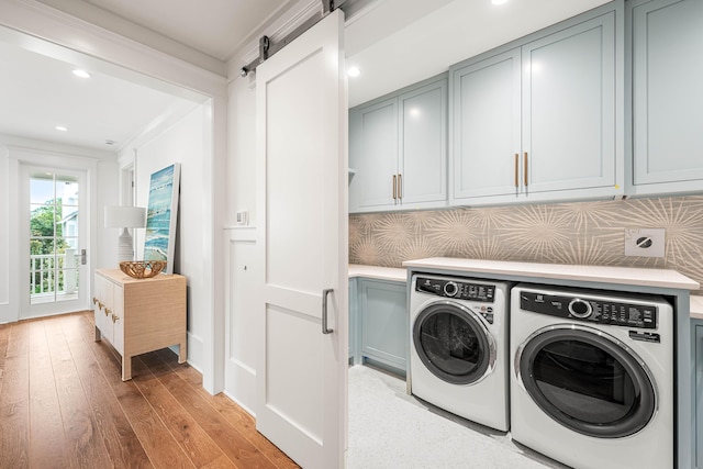 washroom featuring washer and dryer, recessed lighting, a barn door, cabinet space, and light wood finished floors