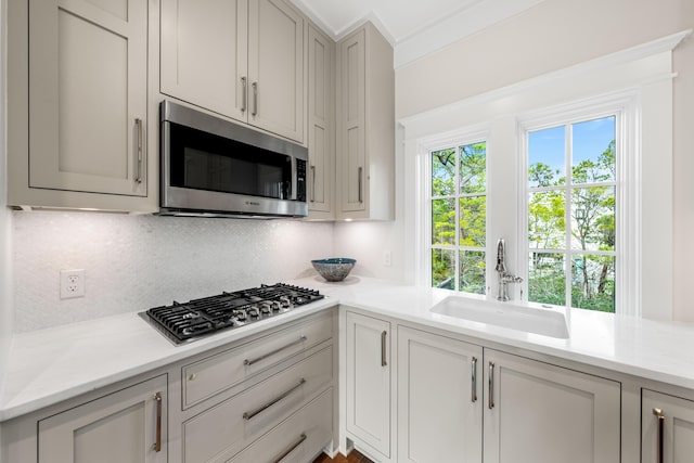 kitchen with a sink, decorative backsplash, and stainless steel appliances