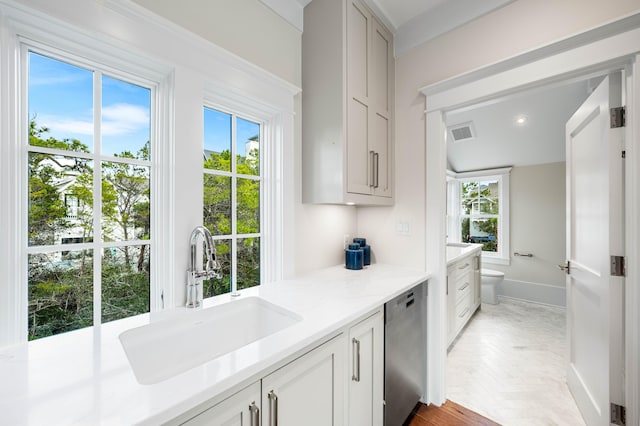 kitchen with visible vents, a sink, plenty of natural light, light countertops, and dishwasher