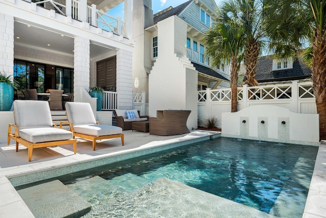 outdoor pool with an outdoor living space, a patio, and fence