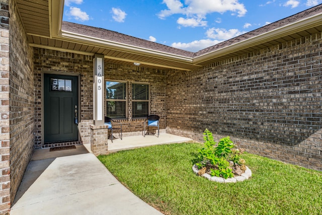 view of exterior entry featuring a lawn