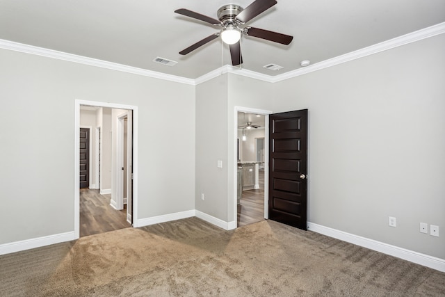 unfurnished bedroom featuring ornamental molding, dark colored carpet, and ceiling fan