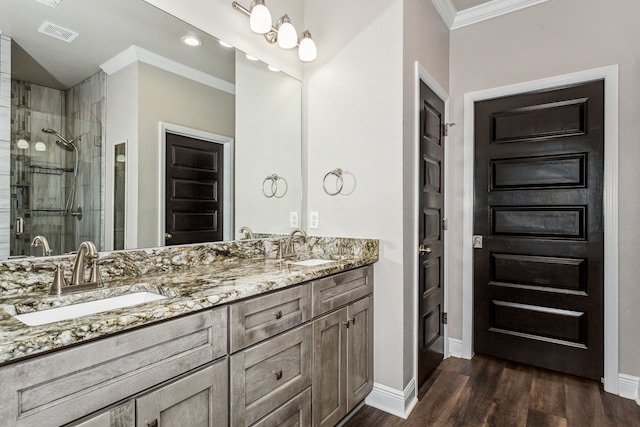 bathroom with vanity, ornamental molding, wood-type flooring, and an enclosed shower