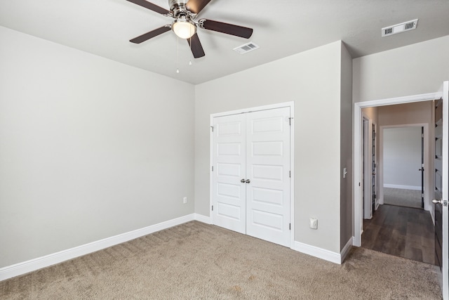 unfurnished bedroom featuring carpet floors, a closet, and ceiling fan