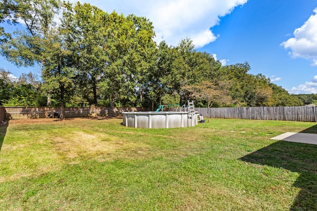 view of yard with a fenced in pool