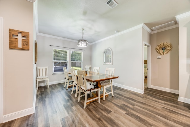 dining space with dark wood-type flooring and crown molding