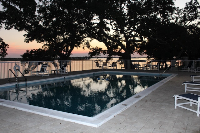 209 W Miracle Strip Pkwy Apt A104, Mary Esther, FL 32569 - pool at dusk featuring fence, a community pool, and a patio area