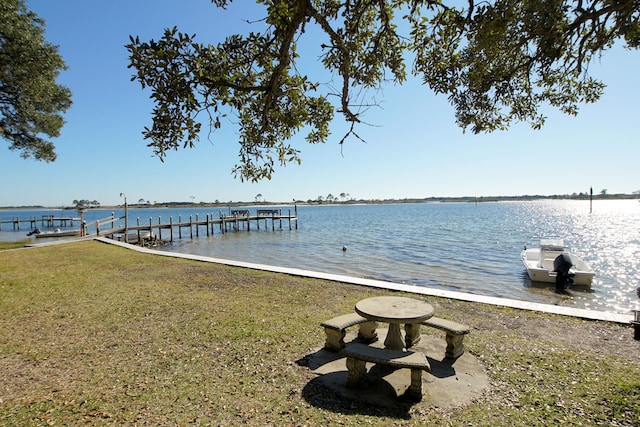 dock area with a water view and a yard