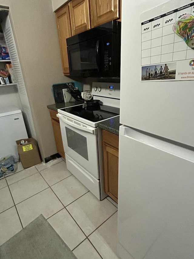 kitchen with light tile patterned floors and white appliances