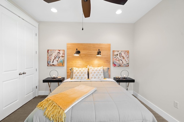 bedroom featuring dark colored carpet, a closet, and ceiling fan