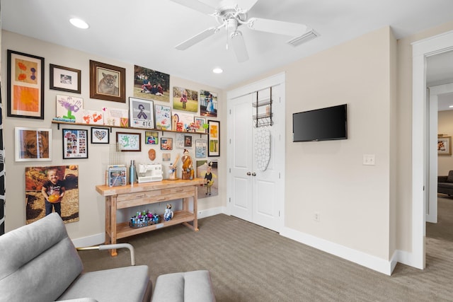 living area with ceiling fan and carpet floors