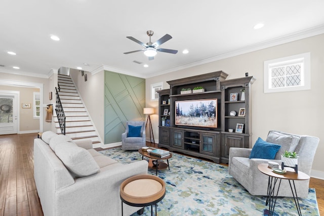 living room with ornamental molding, wood-type flooring, and ceiling fan