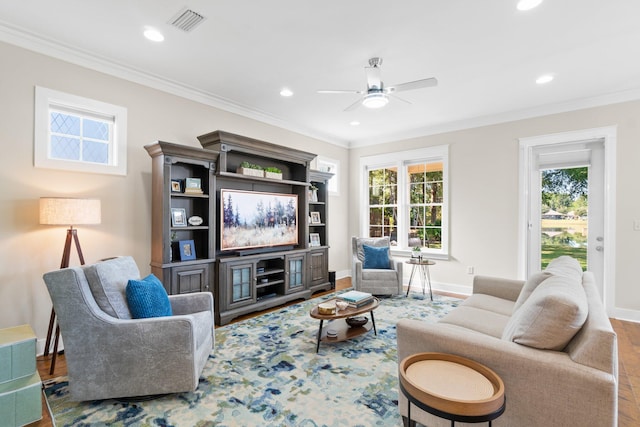 living room featuring ornamental molding, hardwood / wood-style flooring, plenty of natural light, and ceiling fan